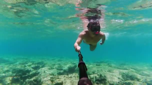 Hombre disparando vídeo bajo el agua sobre sí mismo por su cámara de acción — Vídeo de stock