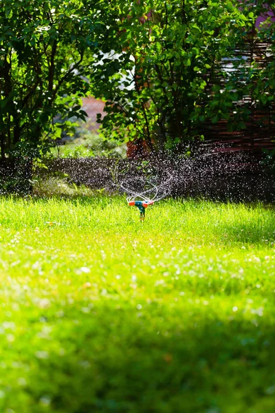Rotierender Gartenregner, der Gras gießt — Stockfoto