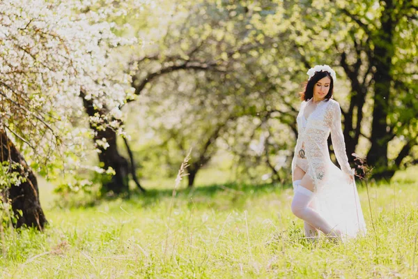 Verleidelijke jonge bruid in witte neglige en kousen — Stockfoto