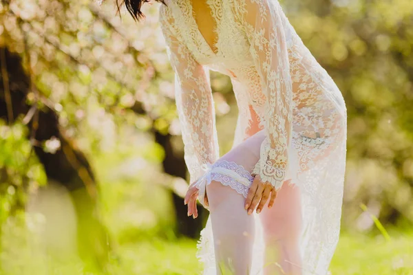 Jeune mariée séduisante en négligée blanche et jarretelles dressing jarretière — Photo