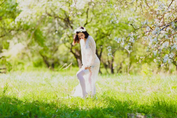 Verleidelijke jonge bruid in witte neglige en dressing jarretelles kousen — Stockfoto