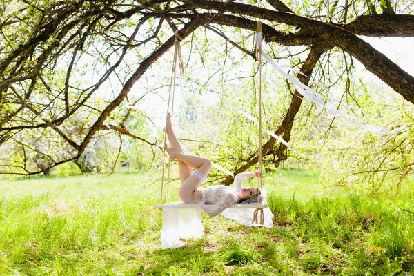 Baştan çıkarıcı poz beyaz bir salıncak üzerinde döşeme genç seksi gelin