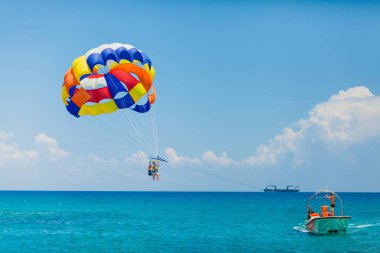Çift renkli bir paraşüt üzerinde uçan turist