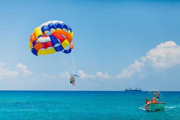 Casal de turistas voando em um paraquedas colorido — Fotografia de Stock