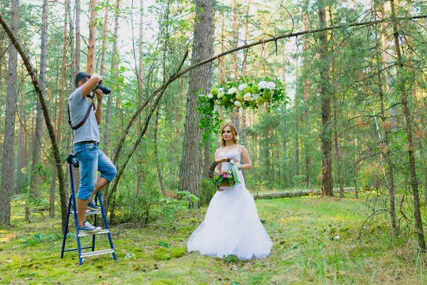 Wedding photographer using stepladder to make pictures of the bride
