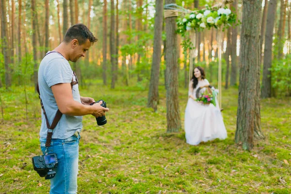 Fotografo che fotografa la sposa su un'altalena di corda — Foto Stock