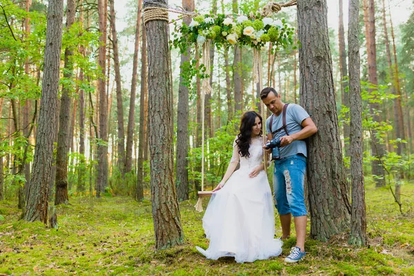 Photographe et mariée regardant des photos prises récemment — Photo