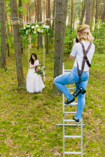Professionele trouwfotograaf trapladder gebruik te maken van de foto's van de bruid — Stockfoto