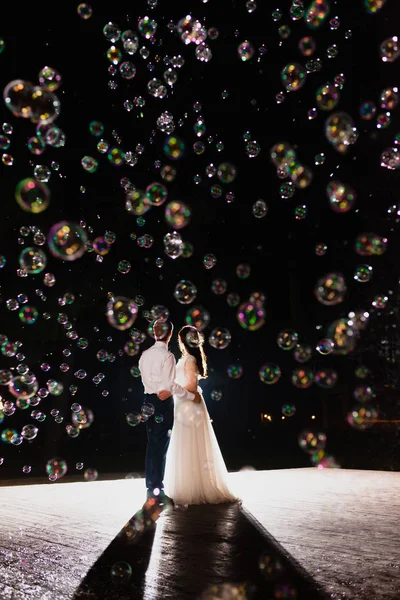 Paar jonggehuwden en enorme hoeveelheid bubbels vliegen in de lucht — Stockfoto