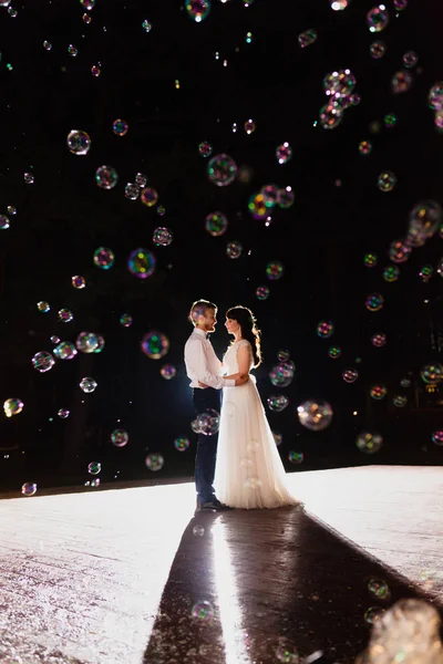 Casal de recém-casados na escuridão no fundo do flash de luz — Fotografia de Stock