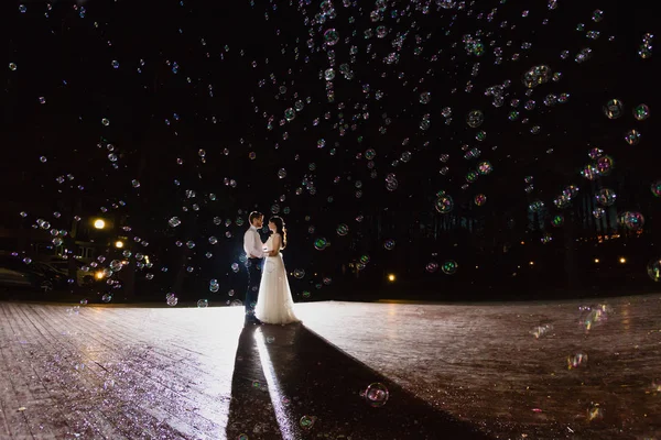 Coppia di sposi novelli e una grande quantità di bolle stanno volando in aria — Foto Stock