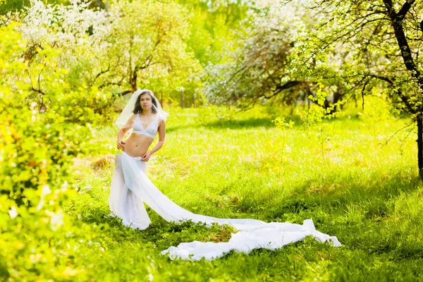 Młoda kobieta stwarzających w białej bielizny i spódnica duży kawałek tkaniny biały — Zdjęcie stockowe