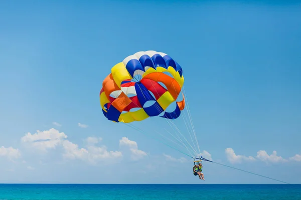 Pareja de turistas volando en un colorido paracaídas — Foto de Stock