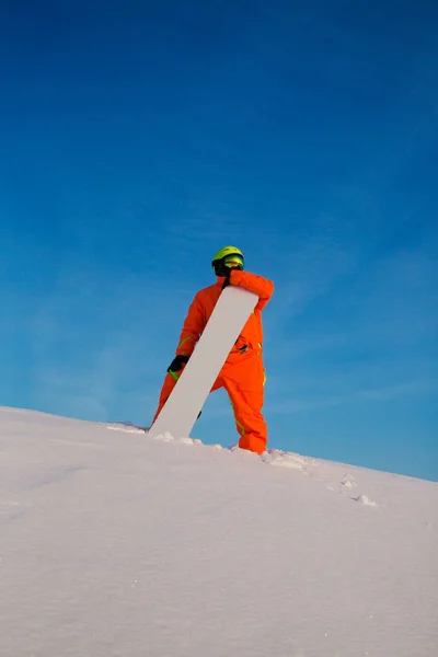 Сноубордист-фрирайдер с белым сноубордом, стоящим на вершине лыжного склона — стоковое фото