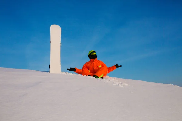 Snowboarder freerider met witte snowboard zitten bovenop de skipiste — Stockfoto