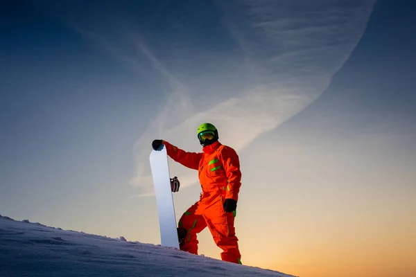 Snowboarder op de bovenkant van de skipiste op de achtergrond van de prachtige zonsondergang — Stockfoto