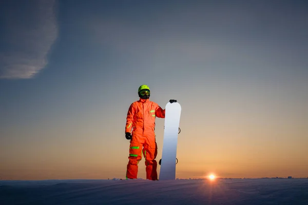 Snowboarder en la cima de la pista de esquí en el fondo de la hermosa puesta de sol —  Fotos de Stock