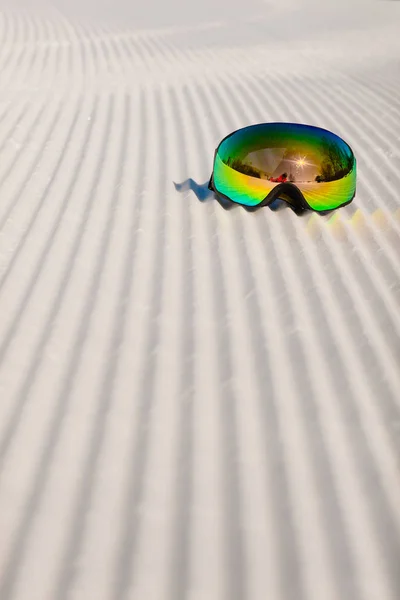 Skibrille opleggen aan een nieuwe geprepareerde sneeuw en lege skipiste — Stockfoto