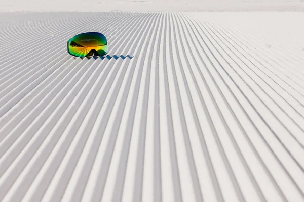 Skibrille opleggen aan een nieuwe geprepareerde sneeuw en lege skipiste — Stockfoto
