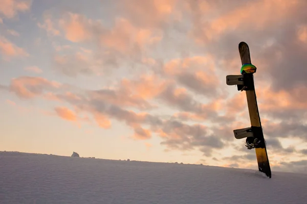 Texture en poudre et équipement pour le snowboard au coucher du soleil — Photo