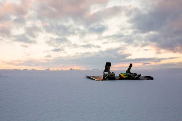 Pudrig textur och utrustning för snowboard vid solnedgången — Stockfoto