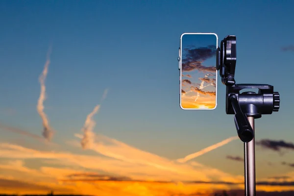 Çarpıcı gün batımından yakalamak için tripod üzerinde Smartphone kullanarak