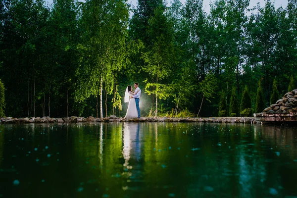 Casal de recém-casados na escuridão no fundo do flash de luz — Fotografia de Stock