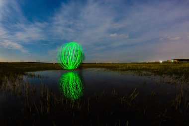 Nehir yüzeyinde yansıyan fütüristik parlayan küre