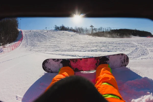 Точка зору знімок чоловічого сноубордиста сидить на снігу — стокове фото