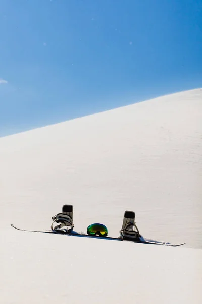 Snowboard și ochelari de schi așezați pe o zăpadă lângă pârtia freeride — Fotografie, imagine de stoc