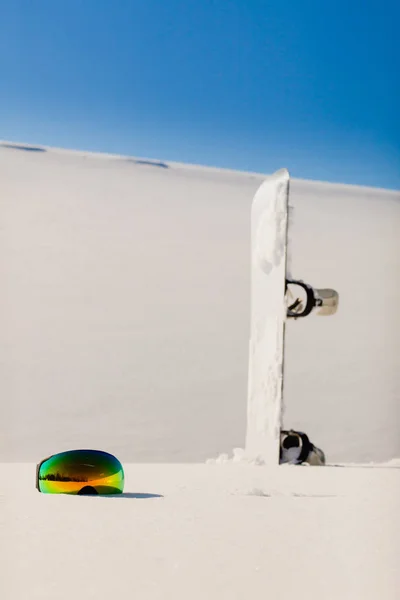 Snowboard și ochelari de schi așezați pe o zăpadă lângă pârtia freeride — Fotografie, imagine de stoc