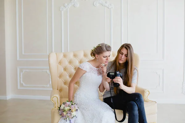Fotograf zeigt junge sexy Braut, die gerade Fotos gemacht hat — Stockfoto