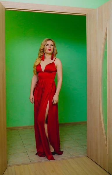 Привлекательная блондинка в красном платье позирует в студии — стоковое фото