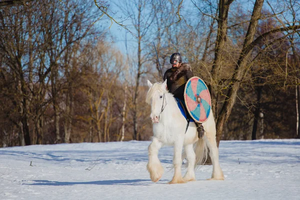 Hombre en traje de vikingo antiguo montar a caballo blanco grande — Foto de Stock