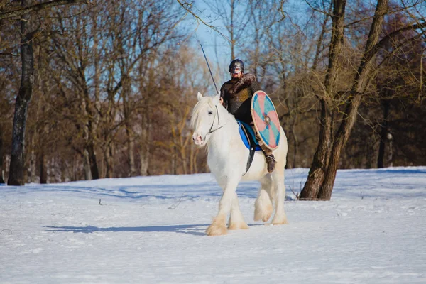 Hombre en traje de vikingo antiguo montar a caballo blanco grande — Foto de Stock