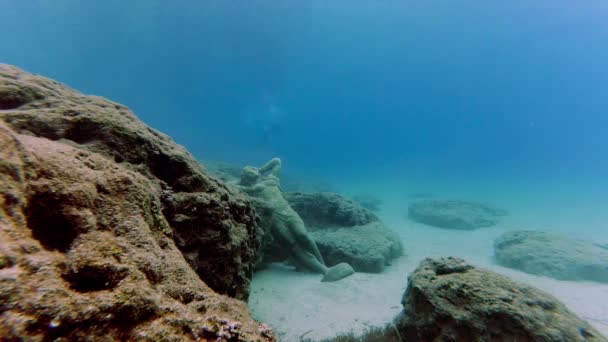 Podvodní scéna se sochou na dně moře a několika potápěči — Stock video