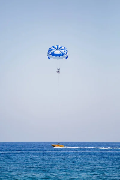 Pareja de turistas vuela en un paracaídas azul y blanco —  Fotos de Stock