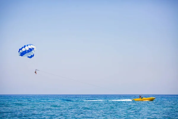 Pareja de turistas vuela en un paracaídas azul y blanco — Foto de Stock