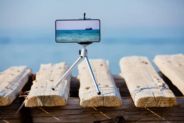 Smartphone en trípode haciendo foto y video del paisaje marino — Foto de Stock