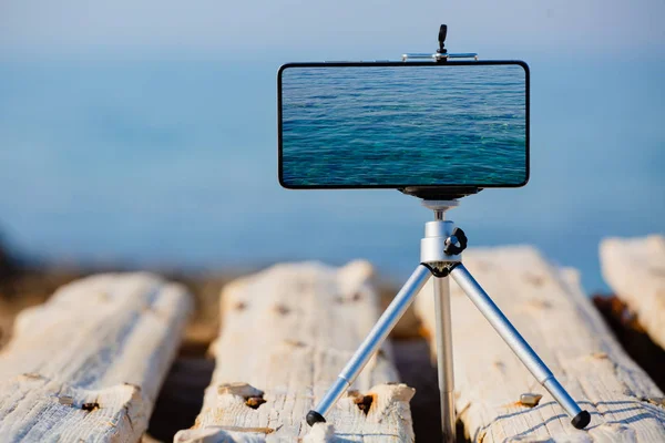 Smartphone en trípode haciendo las fotos de la hermosa superficie del agua — Foto de Stock