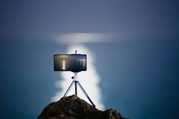 Usando el teléfono inteligente en el trípode para hacer la foto con la hermosa carretera lunar — Foto de Stock