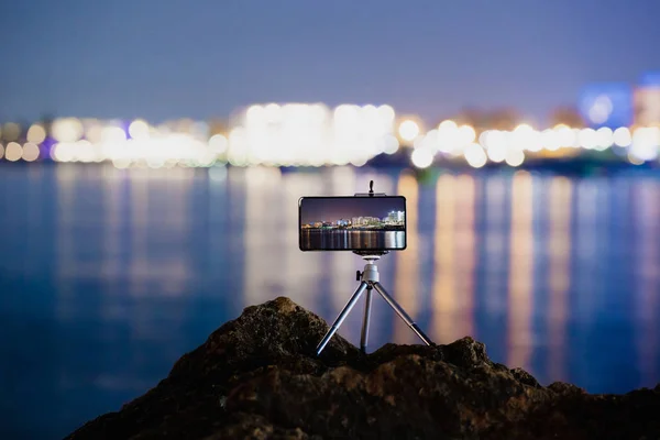 Використання смартфона на тринозі для створення фотографії нічного пейзажу — стокове фото