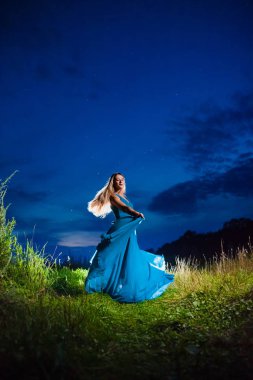 Uzun mavi hava elbisesi güzel sarışın model ışık ışını poz