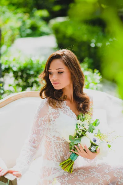 Gros plan portrait de jeune belle mariée en négligee blanc avec bouquet nuptial — Photo