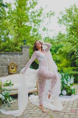 Beyaz negligee beyaz kumaş büyük bir parça ile poz baştan çıkarıcı genç gelin