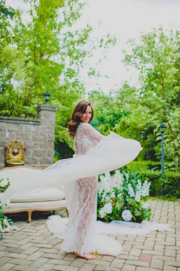 Beyaz negligee beyaz kumaş büyük bir parça ile poz baştan çıkarıcı genç gelin