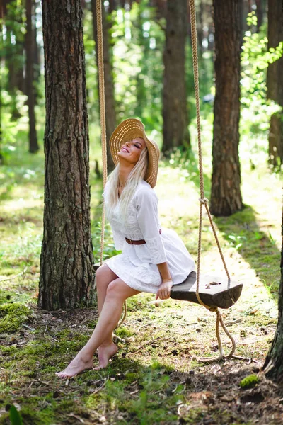 Blond vrouw met slanke mooie naakte benen zitten met op een touw swing — Stockfoto