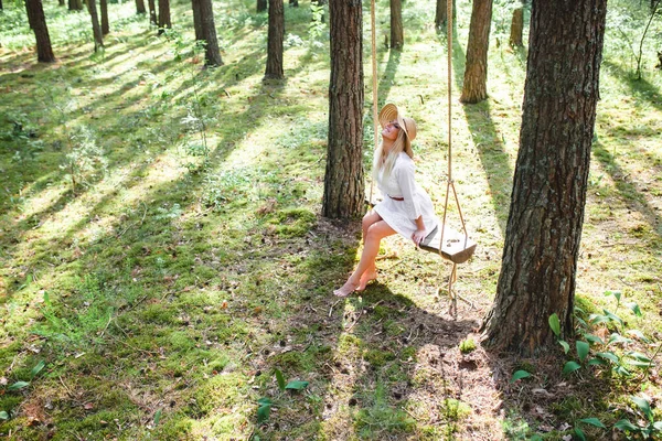 Femme blonde avec de belles jambes nues minces assis avec sur une balançoire de corde — Photo