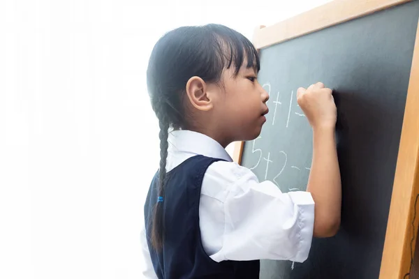 亚洲的中国小女孩在孤立的白色背景在黑板上写 — 图库照片