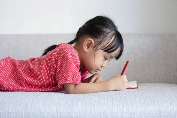 Ασιατική Κινέζικη Κοριτσάκι Τοποθέτηση Στο Βιβλίο Γραφής Καναπές Στο Σαλόνι — Φωτογραφία Αρχείου